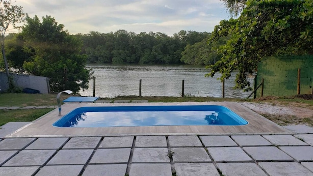 Una piscina rettangolare con rivestimento interno blu, circondata da un solarium in pietra.