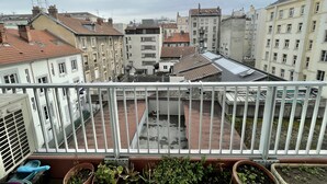 A balcony with potted plants, overlooking a courtyard with buildings in the background. - #CX |Chez Faffa 𓅂| Spacious T5 | Train station | (Grenoble)