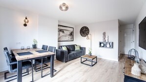 Una sala de estar moderna con una mesa de comedor, sofá y objetos decorativos.