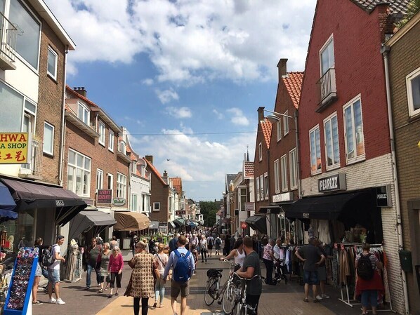 A bustling street with shops and pedestrians.