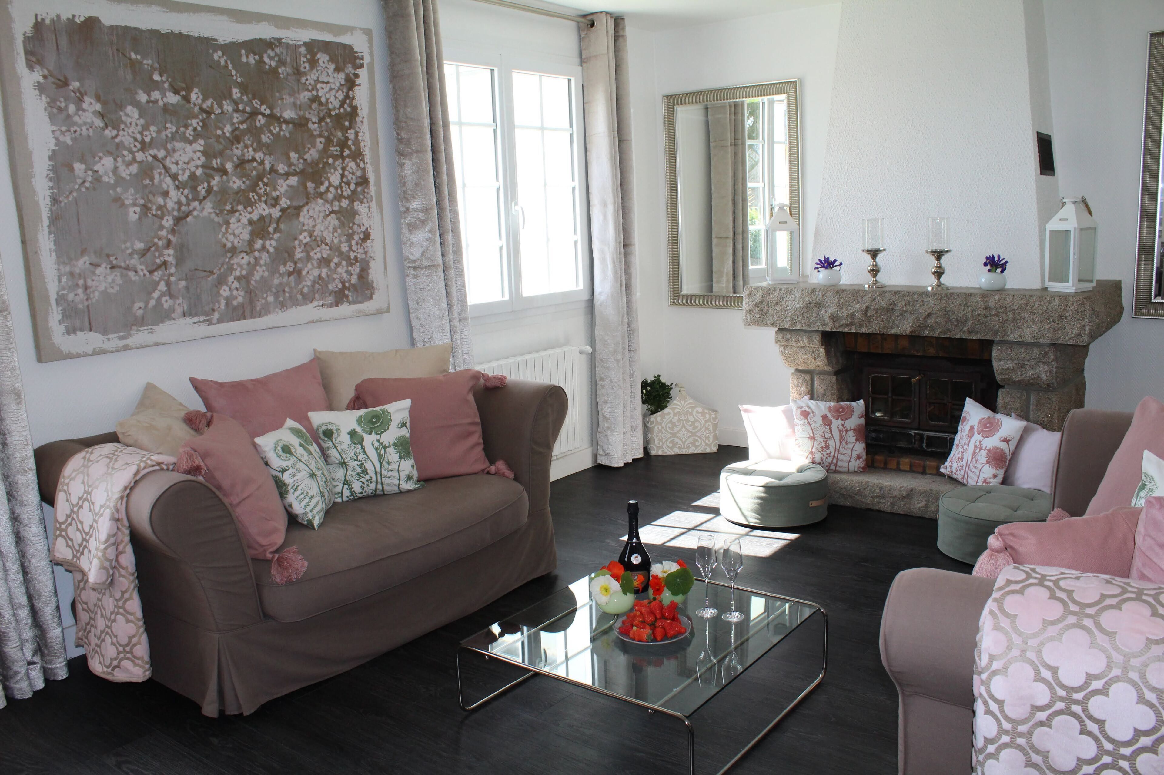 A living room with a brown sofa, a glass coffee table, and a fireplace.