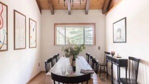 A dining area with a wooden table, black chairs, and framed artwork on the walls. - Lakeshore Villa (Incline Village)