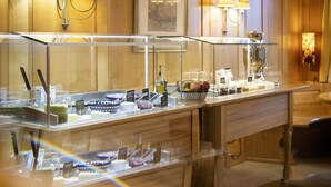 Un bar pour le petit-déjeuner doté d’une vitrine, de lambris en bois et de lampes fixées au mur.