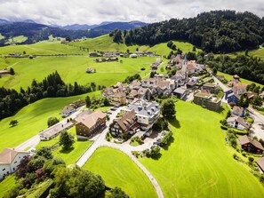 Eine Vogelperspektive eines Dorfes mit Häusern, Straßen und grünen Feldern.