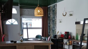 A compact kitchen with a wooden bar, a coffee machine, and a microwave. - L'Étoile - studio in the heart of Chinon (Chinon)
