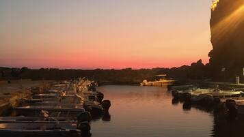 Un port de plaisance au coucher du soleil, avec des bateaux amarrés.