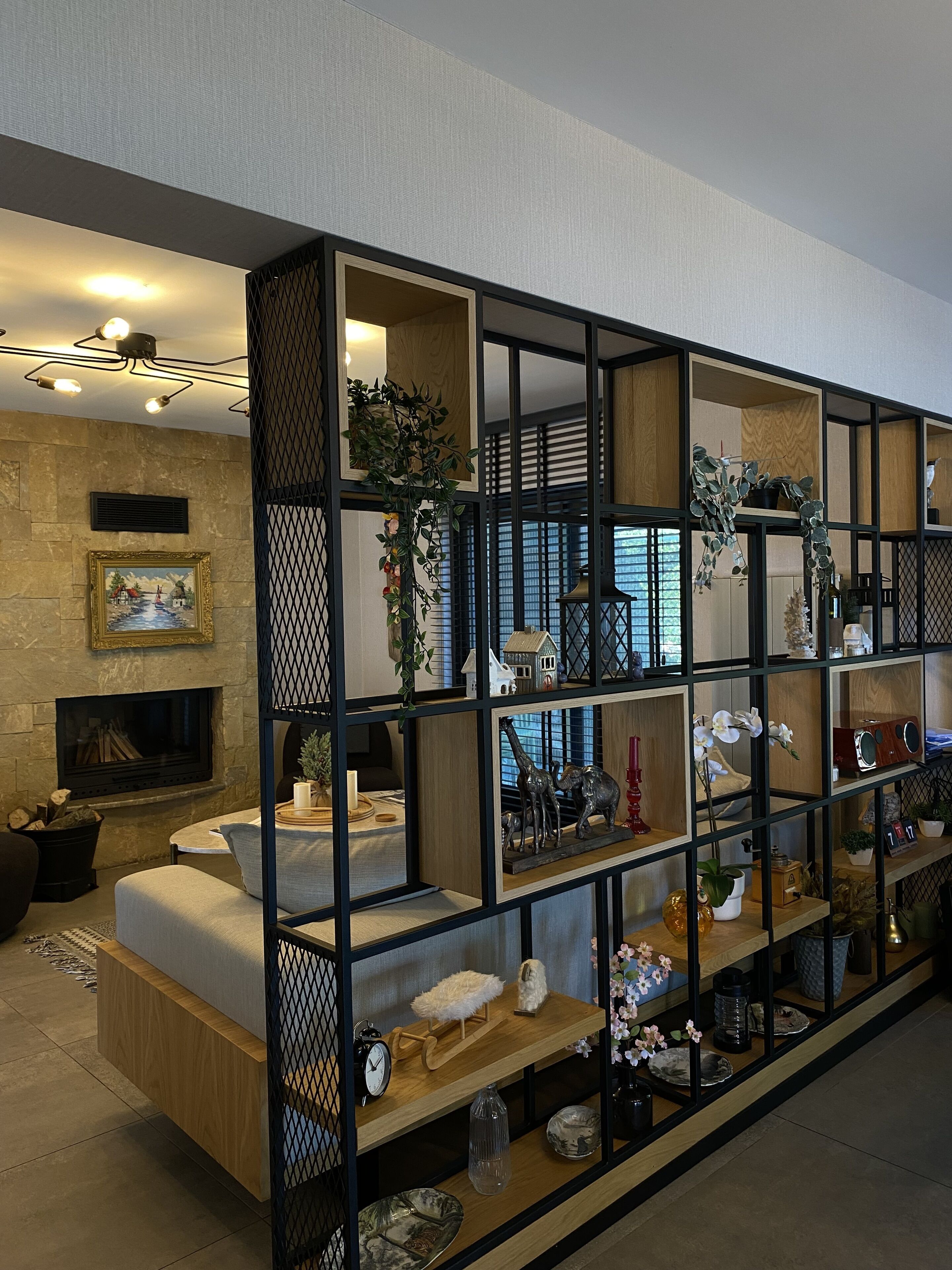 A modern living room with a fireplace, wooden shelves, and various decorative items.