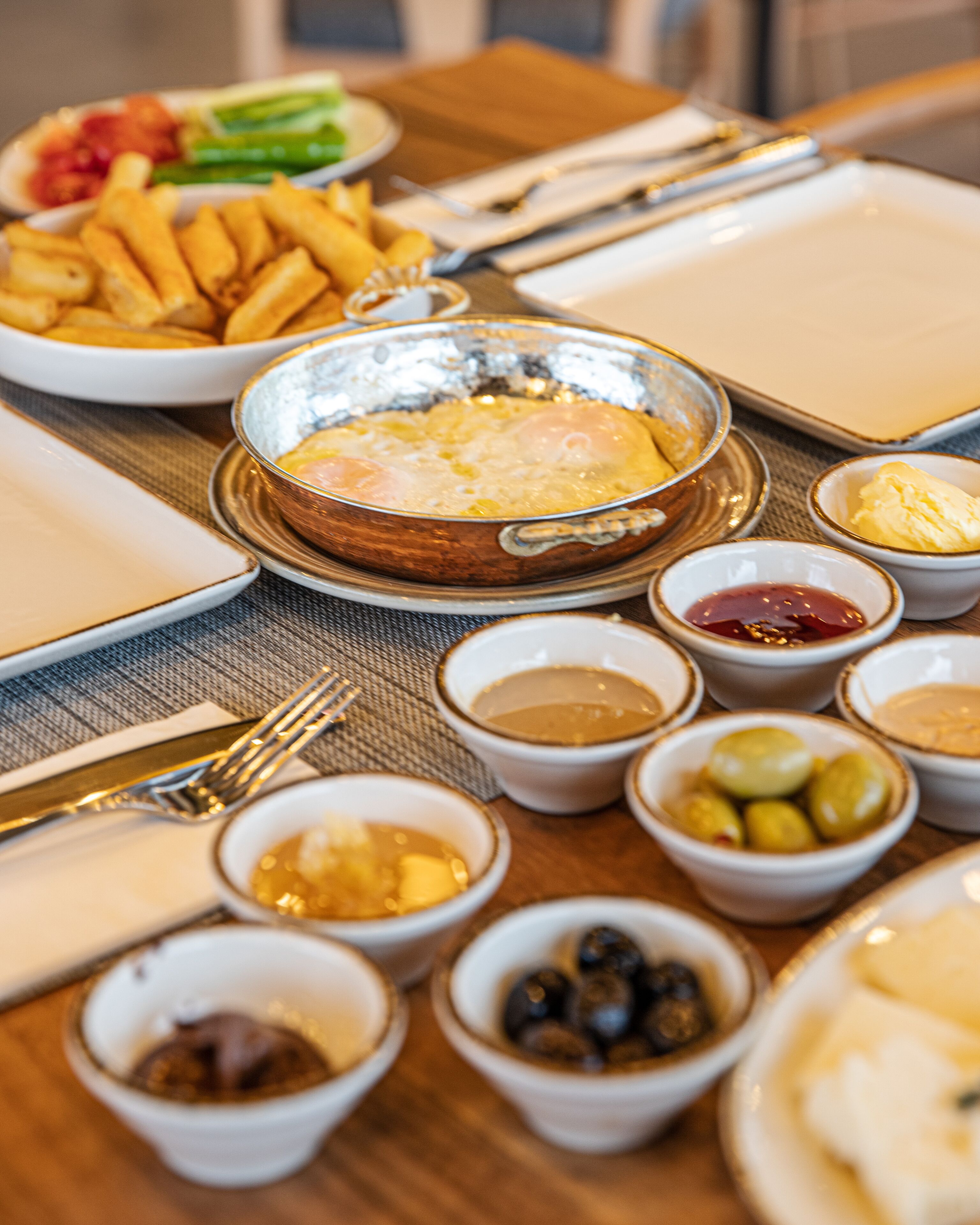 A table set with various dishes including eggs, olives, and condiments.