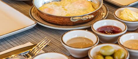 A table set with various dishes including eggs, olives, and condiments.