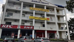 A multi-story building with a KFC restaurant at the ground level, a sign for 'Imperial Heights', and a sign for 'Abuz Z Oxfordcaps' indicating a hostel. - Abuzz Oxfordcaps Dehradun - Campus Accommodation (Dehradun)