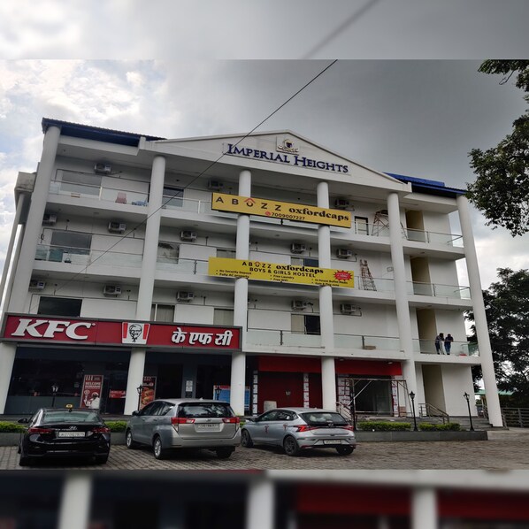 A multi-story building with a KFC restaurant at the ground level, a sign for 'Imperial Heights', and a sign for 'Abuz Z Oxfordcaps' indicating a hostel. - Abuzz Oxfordcaps Dehradun - Campus Accommodation (Dehradun)