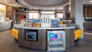 Eine Selbstbedienungs-Getränkestation mit Kühlvitrine, Kaffeeautomat und verschiedenen Snacks.