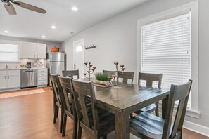 Enjoy meals in the kitchen and dining area with an oven, stainless steel appliances, and a wooden table for six.