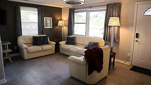 Ein Wohnzimmer mit zwei Sofas, einem Couchtisch und einer Lampe.