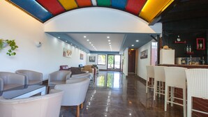 A modern interior with a curved ceiling, a bar area with stools, and a seating area with sofas and chairs. - Nergos Side Hotel (Manavgat)