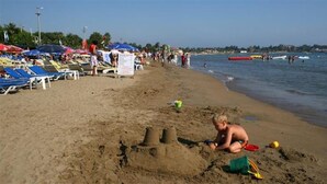 A beach with sandcastles, beach chairs, and umbrellas. - Nergos Side Hotel (Manavgat)
