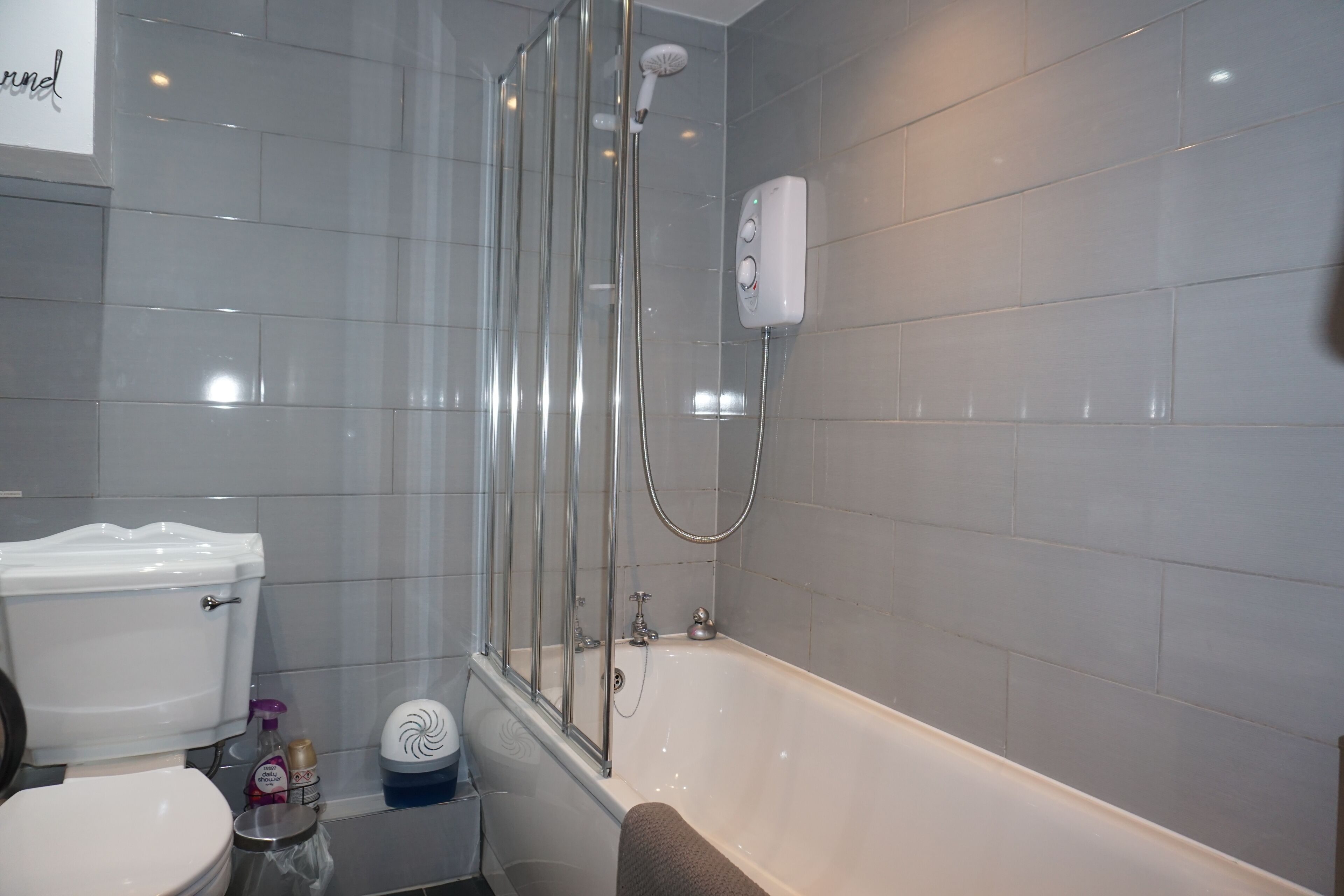 Een badkamer met toilet, douchecabine en bad.