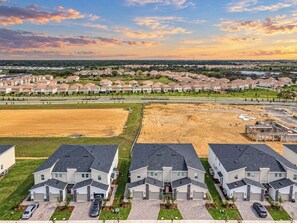 Una zona residencial con casas modernas, un amplio campo abierto y un sitio de construcción.