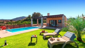 A pool area with lounge chairs, a pergola, and a view of mountains. - Muses Beach Villas - Erato (Sitia)