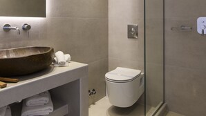 A modern bathroom with a large vessel sink, a glass shower enclosure, and a toilet. - Sunset Windmills Suites (Mykonos)