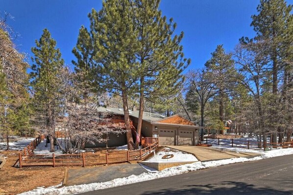 A residential area with a garage, a driveway, and a snow-covered ground.