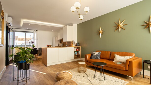 A modern living room with a sofa, coffee table, and decorative star wall art. - Champollion Appartment : A/C + Netflix + Garage (Albi)