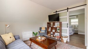 Ein modernes Wohnzimmer mit einer Couch, einem Couchtisch und einem Bücherregal.