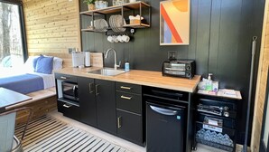 A compact kitchen with a sink, a toaster, and a dishwasher. - The Hemlock Tiny House (Logan)