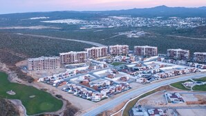 An aerial view of a residential area with multiple apartment buildings, roads, and green spaces.