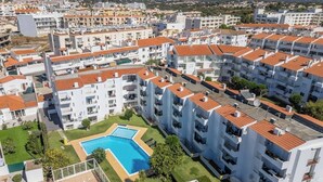 Un quartier résidentiel caractérisé par des bâtiments blancs, des toits recouverts de tuiles rouges et une piscine.