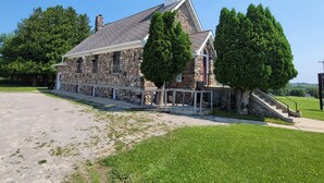 A stone building with a sloped roof and a small tower.