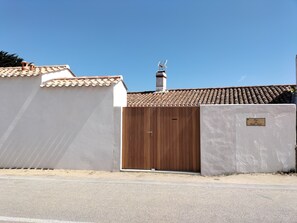 Une propriétéClose, dotée d’un toit en tuiles, d’un portail en bois et d’une cheminée.