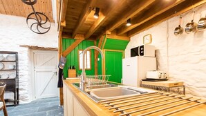 Una cocina con encimera de madera, pileta de acero inoxidable y un tendedero.