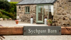 A stone building with a sign reading "Sychpant Barn". - A beautiful barn conversion nestled amongst the hills.. (Crymych)