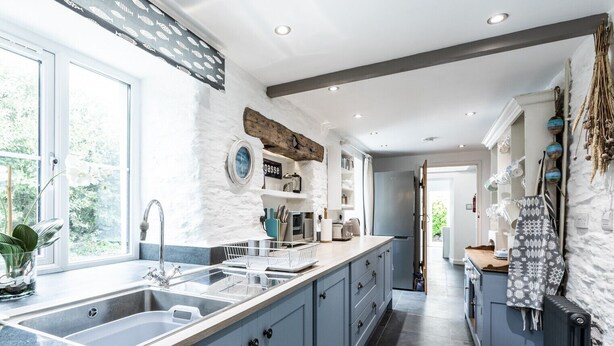 A modern kitchen with a large island, built-in appliances, and a view to the outdoors. - A gorgeous property right on the beach - perfect for families (Newport)