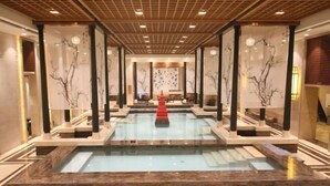 A spa area with a central pool, wooden columns, and a red decorative element. - Yi Jin Hotel (Harbin)
