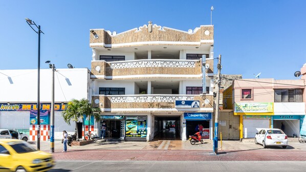 A multi-story building with a ground floor featuring various shops and a visible entrance. - Hotel Damar Valledupar (Valledupar)