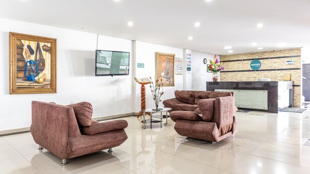 A modern hotel lobby with a reception desk, brown sofas, and artwork on the walls. - Hotel Damar Valledupar (Valledupar)