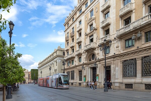 A tram moving along a street with historic buildings on either side.