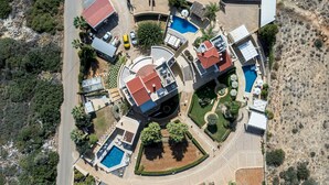 An aerial view of a resort with multiple buildings, a swimming pool, and landscaped areas. - Azzuro Villa by Estia (Hersonissos)