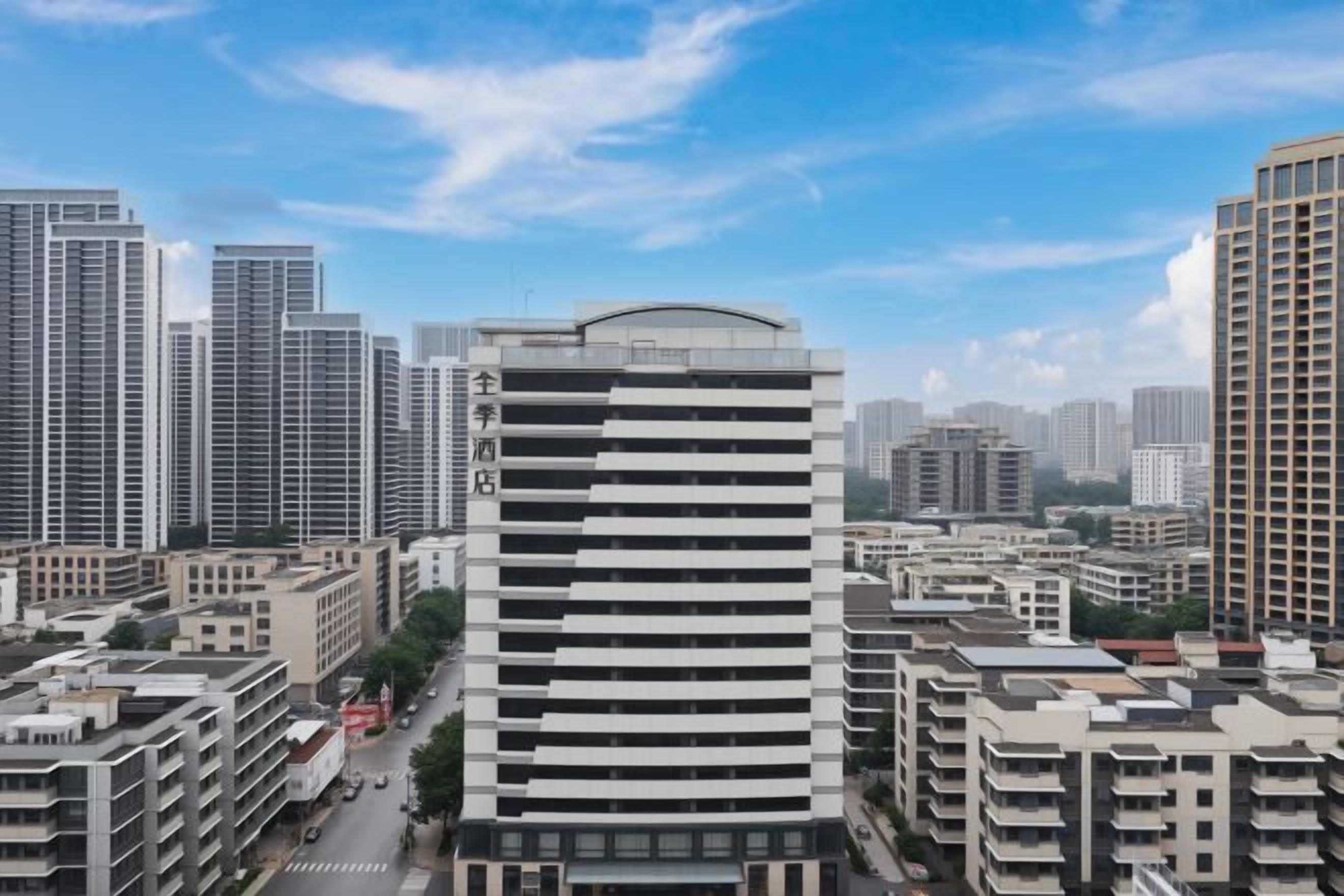 A high-rise building with a modern design, surrounded by other high-rise buildings in an urban setting.