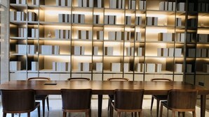 A modern library with bookshelves, a wooden table, and chairs. - JI Hotel (Wuhan Hankou Railway Station Tangjiadun) (Wuhan)