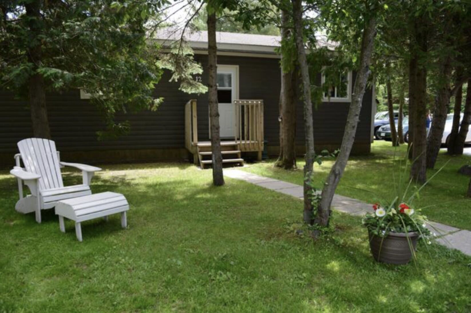 A small, single-story house with a covered porch and a lawn.