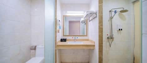 Un baño con inodoro, lavabo, espejo y ducha.
