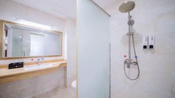A modern bathroom with a large mirror, a sink, and a shower.