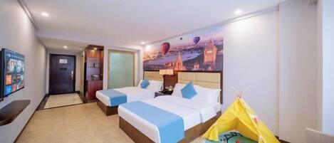 A hotel room with two beds, a television, a wall mural, and a tent.