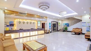 A spacious lobby with a reception desk, seating area, and a staircase. - Zhaoqing Jinyuan Hotel (Zhaoqing)