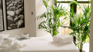 Relax in a serene space with a neatly made bed, a small table for self-service breakfast, and a touch of greenery.