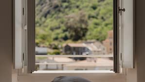 Un dormitorio con ventana que da a un paisaje montañoso.