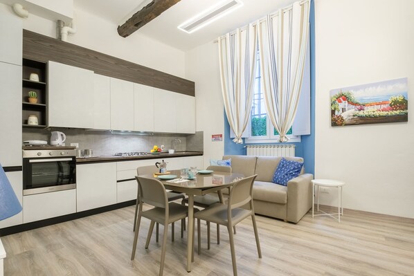 Een moderne keuken met een eethoek, een bank en een schilderij aan de muur.